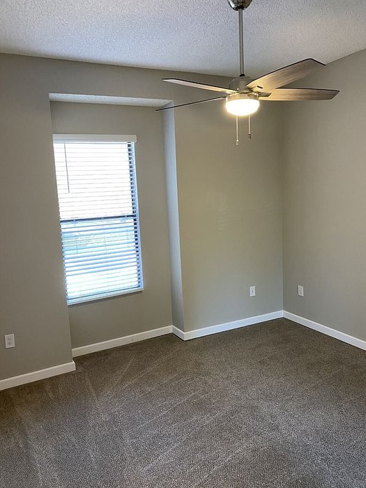 Comfortable bedroom with a window and ceiling fan at Elan - Terraza La Jolla