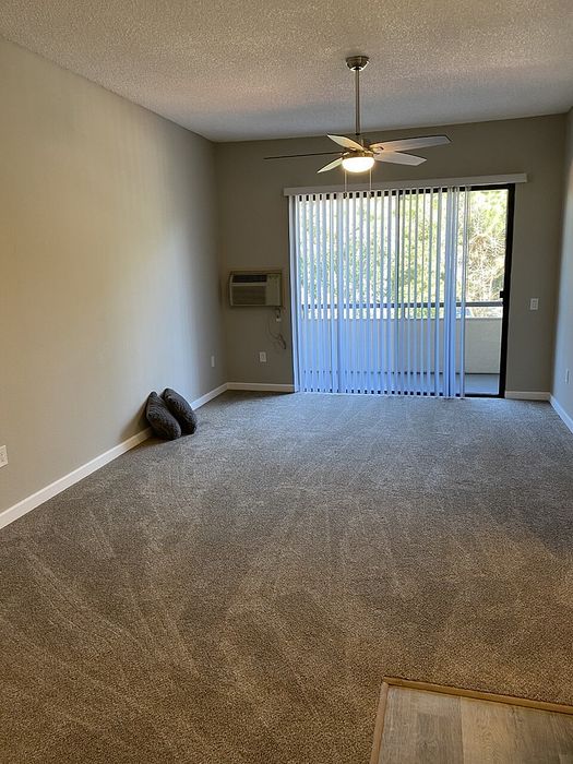 Living area with a ceiling fan and balcony access at Elan - Terraza La Jolla