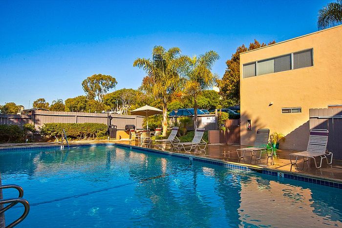 Relaxing community pool area surrounded by palm trees at Elan - Sandpiper Del Mar