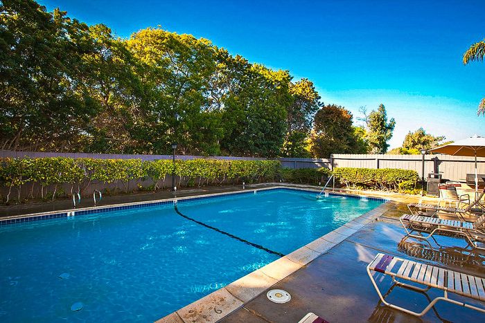 Sparkling swimming pool and sun deck with lounge chairs at Elan - Sandpiper Del Mar