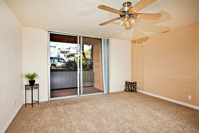 Bright living area with a ceiling fan and balcony access at Elan - Sandpiper Del Mar