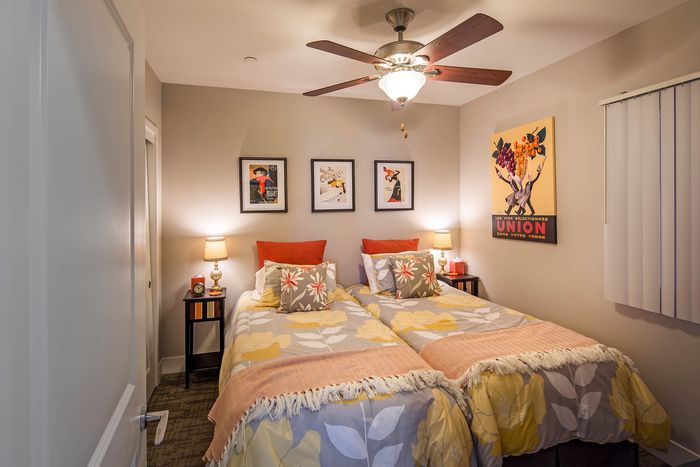 Modern bedroom featuring a ceiling fan and warm lighting at Elan - Luxo II.