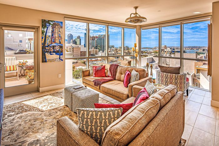 Living room with plush seating and city views at Elan - Luxo II.
