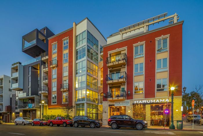 Vibrant urban apartment exterior with street-level retail at Elan - Luxo II.
