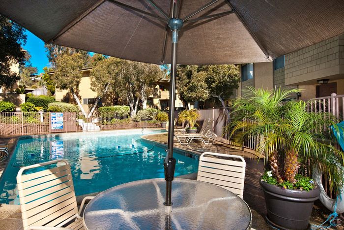 Poolside patio table with umbrella for shaded lounging at Elan - Solana Pointe.