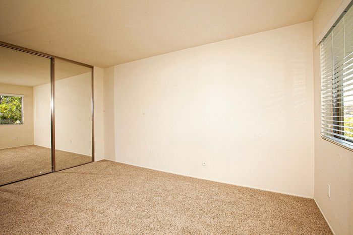 Spacious bedroom featuring mirrored closet doors at Elan - Solana Pointe.