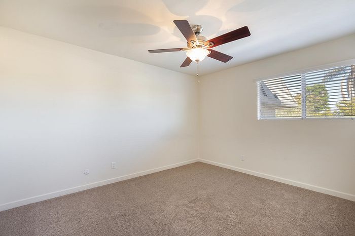 Spacious one-bedroom with ceiling fan and plush carpet at Elan - Sandrock Place