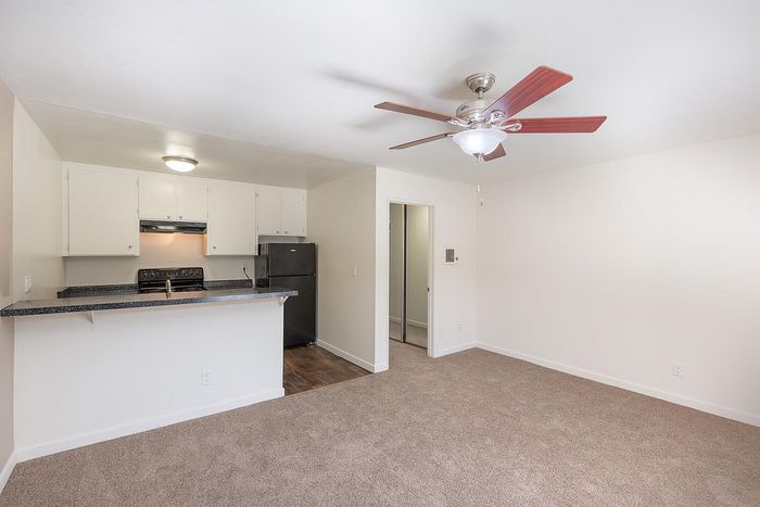 Fully equipped kitchen with white cabinets and ceiling fan at Elan - Sandrock Place