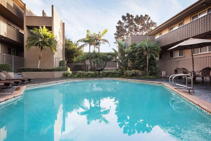Sparkling swimming pool and sun deck with lounge chairs at Elan - Baylofts