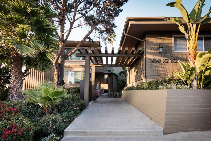 Landscaped resident walkway between modern apartment buildings at Elan - Baylofts