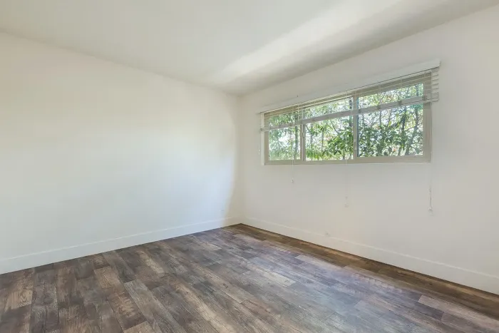 Bright room with wood-style flooring and natural light at Elan - Baylofts