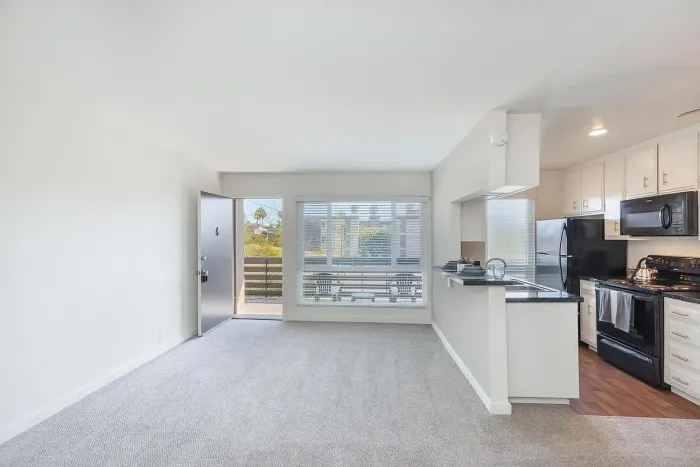 Bright living space featuring a large window and kitchen view at Elan - pacific lofts