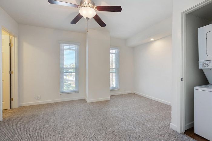 Spacious bedroom with ceiling fan and large window for natural light at Elan - pacific lofts