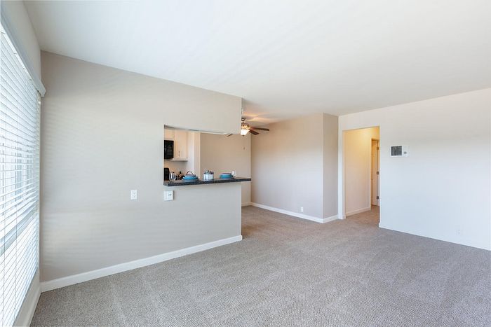 Open living area with plush carpet and neutral walls at Elan - pacific lofts