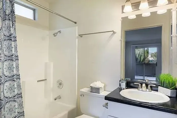 Clean bathroom with a large mirror and tub-shower combo at Elan - poway hills.