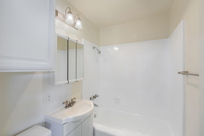 Modern bathroom with a white vanity and tub-shower combo at Elan - beachcomber la jolla.