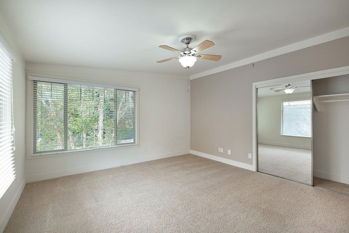 Sunlit room with mirrored closet doors and a large window at Elan - beachcomber la jolla.