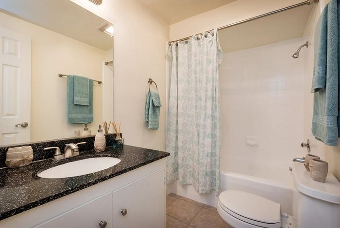 Clean bathroom with a modern vanity and tub-shower combo at Elan - bella mer coronado.