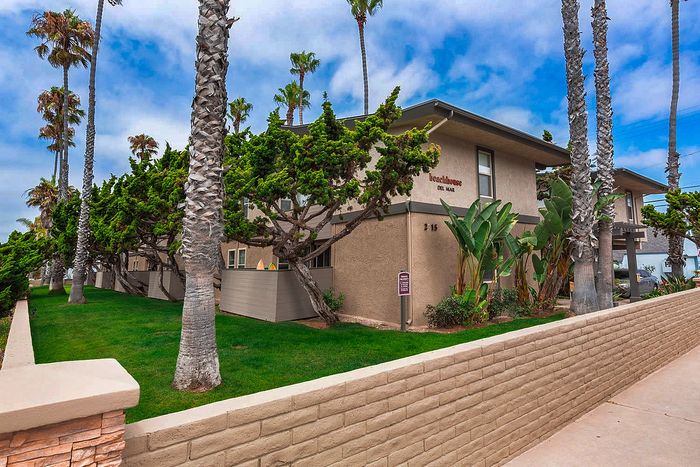 Coastal apartment building with palm trees and lawn at Elan - beachhouse del mar