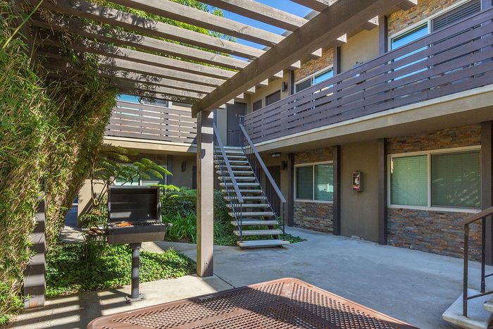 Community BBQ & picnic area with lush courtyard landscaping at Elan - beachlofts del mar