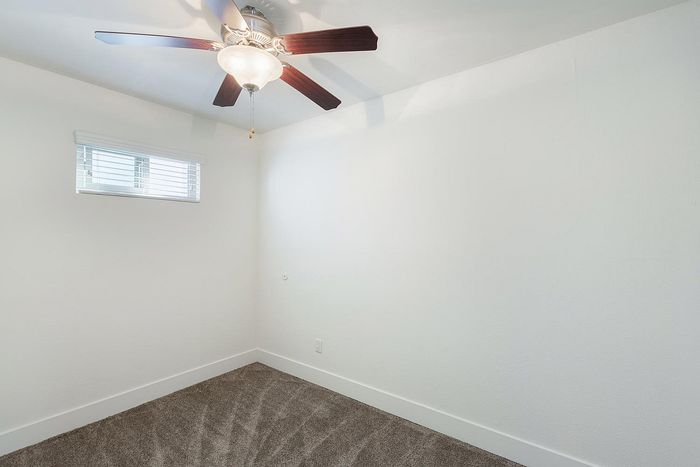 Comfortable bedroom with a ceiling fan and neutral walls at Elan - beachlofts del mar