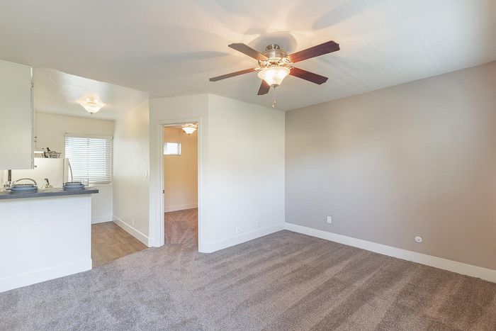 Open living area with plush carpet and ceiling fan at Elan - beachlofts del mar