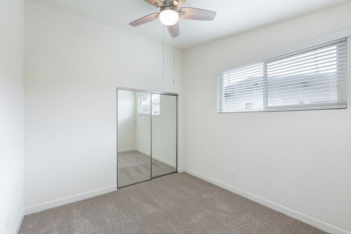 Bright bedroom with mirrored closet doors and carpet at Elan - beachhouse del mar