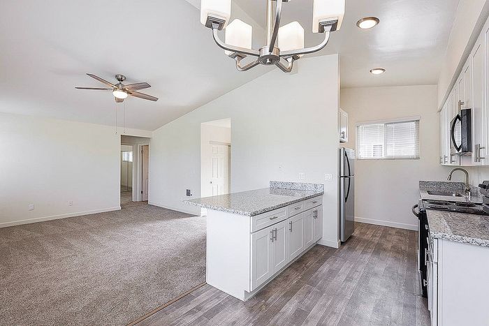 Open living area and kitchen with plush carpet at Elan - beachhouse del mar