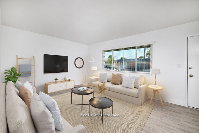 virtually staged living room with large window and wood-inspired flooring