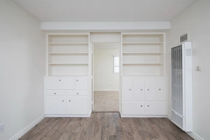 living room with built in bookcase and faux wood flooring at at Avaz Pacific Beach