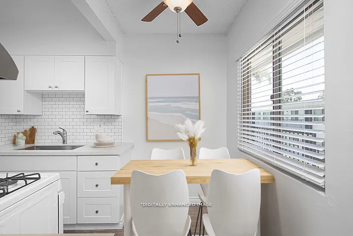 virtually staged dining area with ceiling fan and kitchen