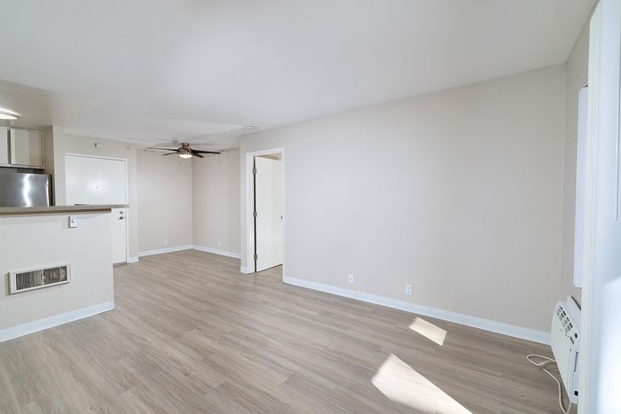 Living space with balcony view, wooden floors, and AC