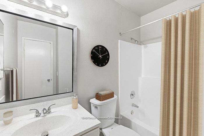 Virtually staged bathroom with sink, toilet, shower, tub, clock, and mirror.