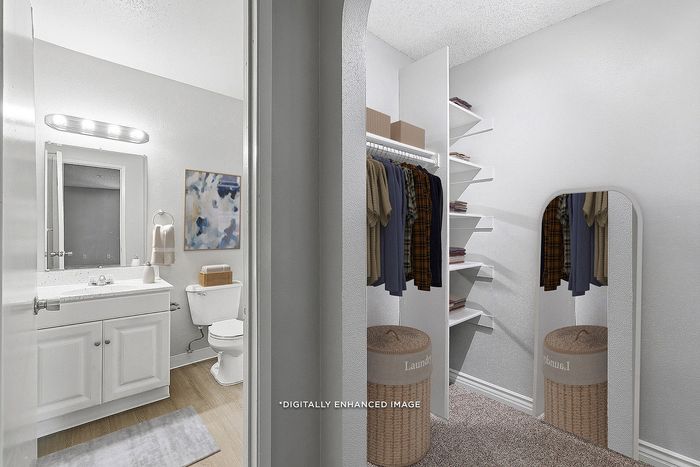 Virtually staged closet and bathroom with clothing, laundry basket, sink, mirror, and storage shelves.