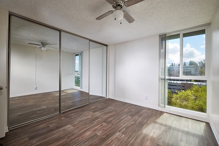 bedroom with sliding closet doors and wood-like flooring at mellmanor