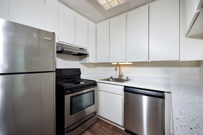 kitchen with stainless steel appliances and wood-like flooring at mellmanor