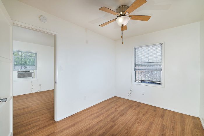 Bedroom with fan and wooden floor