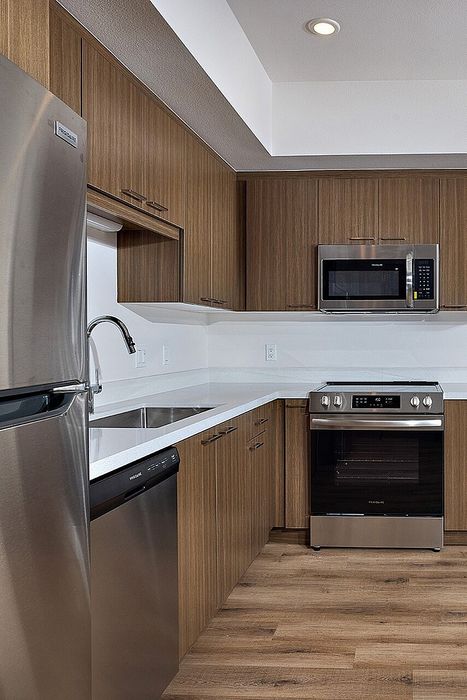 kitchen with fridge, sink, dishwasher, oven, and microwave