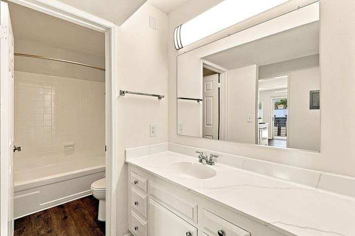 bathroom with bath, sink, and mirror