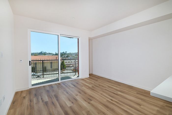 textur apartment living room in La Mesa with wood-style flooring and a sliding glass door to a private balcony.