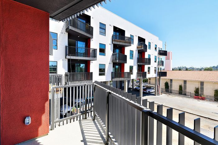 Balcony view of the modern white and red exterior with black metal railings at textur apartments in La Mesa, CA.