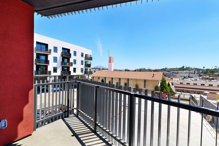 Balcony view at textur apartments showing modern building architecture and the La Mesa neighborhood under blue skies.
