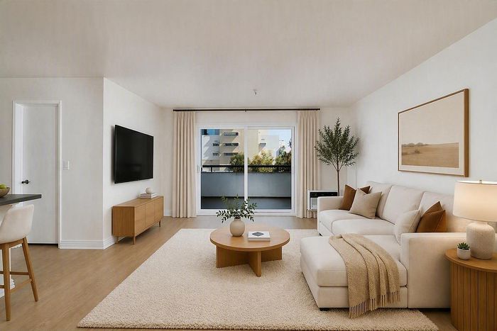 virtually staged-Bright living room with sectional couch, shag rug, and balcony door at The Warwick.