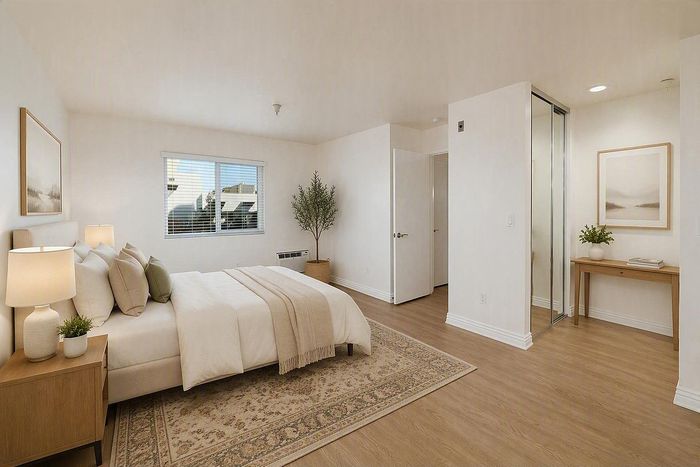 virtually staged-Spacious apartment bedroom with wood flooring and sliding closet at The Warwick.