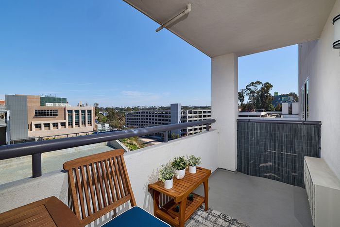 Covered apartment balcony overlooking San Diego cityscape at The Warwick Apartment Homes.