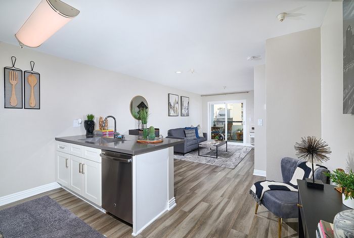 Kitchen peninsula with dark quartz countertops and dishwasher at The Warwick Apartment Homes.