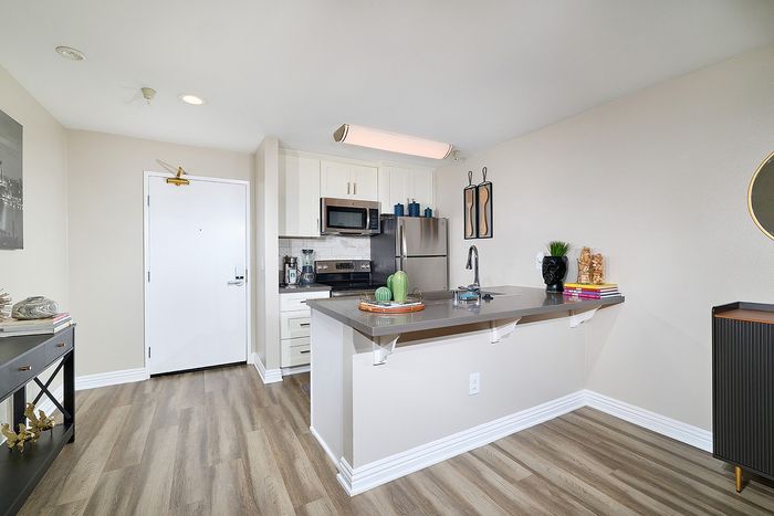 Modern kitchen with stainless steel appliances and white cabinets at The Warwick.