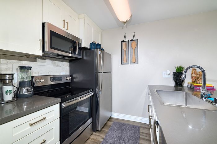 Kitchen finishes showing dark quartz counters and tile backsplash at The Warwick.