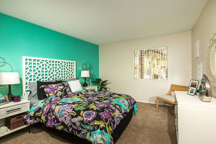 bedroom with green accent wall and furnished with bed and nightstands at metro on main