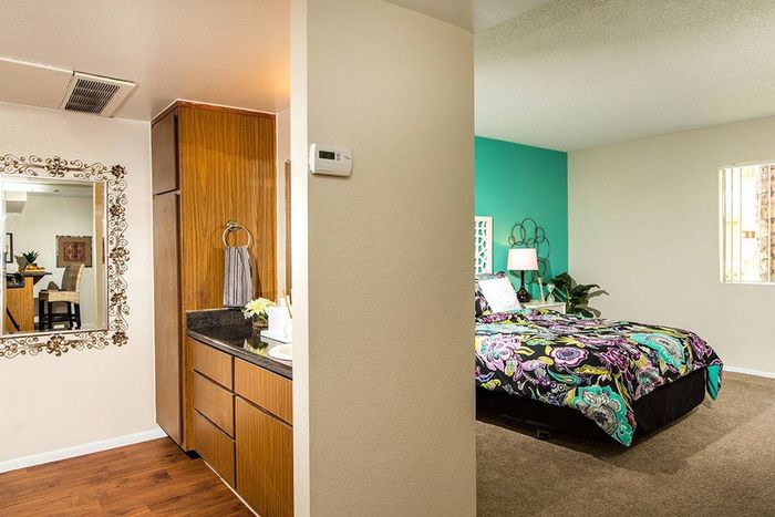 bedroom with green accent wall and furnished with bed and nightstands at metro on main